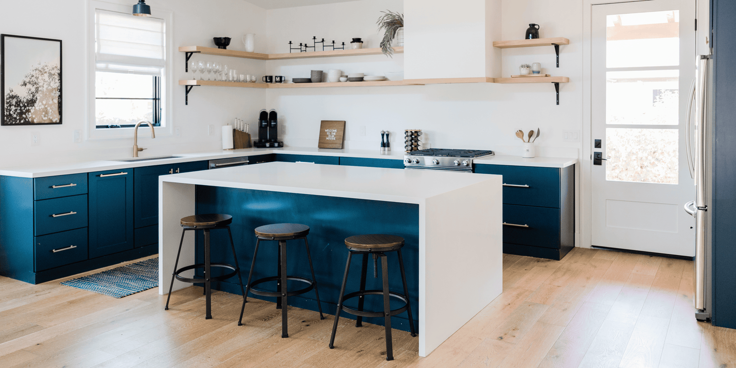 Sleek blue and white kitchen with island and stools, highlighting RenovaHaven’s commitment to practical, aesthetic home tools.