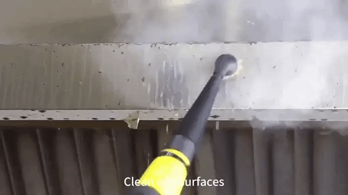 Handheld steam cleaner removing dirt from oily metal surface with steam power