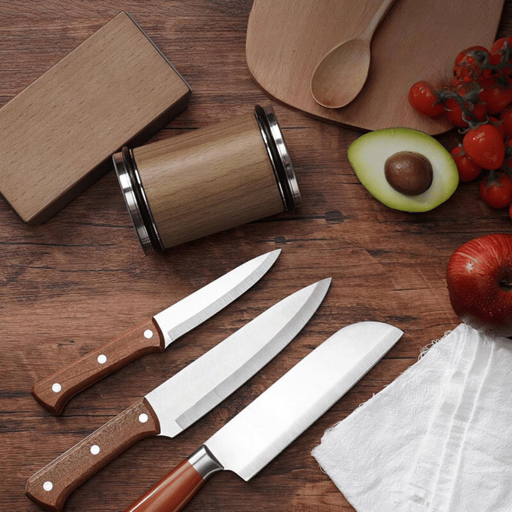 Sharpened kitchen knives beside rolling sharpener on cutting board setup