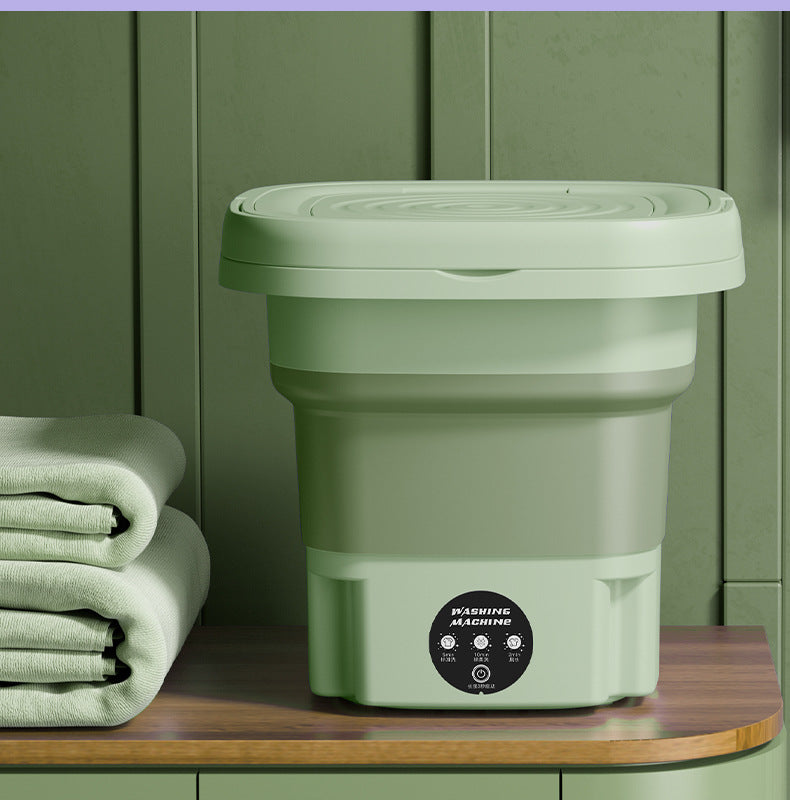 Compact folded washing machine beside a cabinet, ideal for apartments and minimalist setups