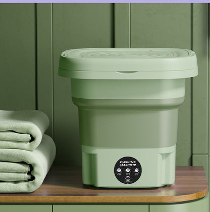 Compact folded washing machine beside a cabinet, ideal for apartments and minimalist setups